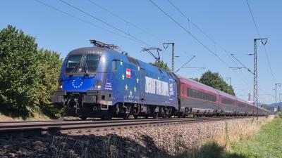 Elektrolokomotive ÖBB Taurus 1116 154 mit einem Railjet in Freilassing