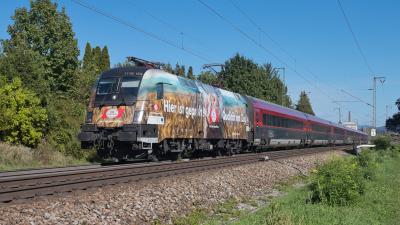Elektrolokomotive Werbelok ÖBB Taurus 1116 156 mit einem Railjet in Freilassing